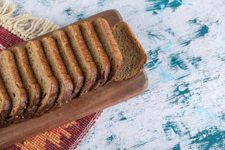 A wooden cutting board with slices of breadの写真素材