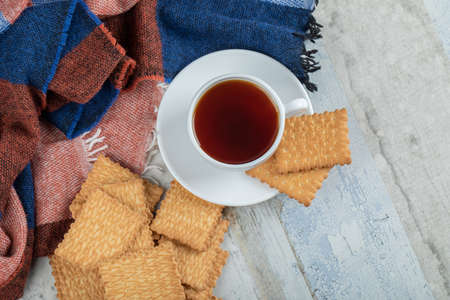 A cup of aroma tea with crackers on a wooden tableの写真素材