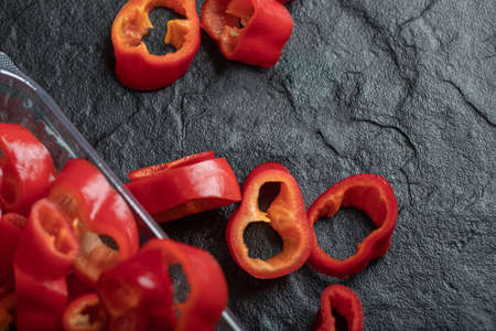 Slices of sweet red peppers on a dark backgroundの写真素材