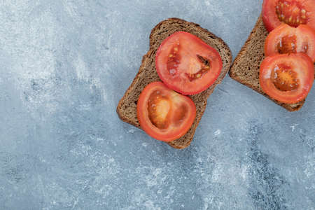 Delicious toasts with slices of tomato on a gray backgroundの写真素材