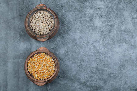 Two pots full of raw peas and popcornの写真素材