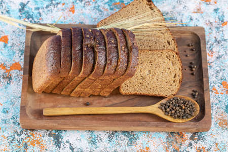 Slices of fresh loaf of bread on a wooden boardの写真素材