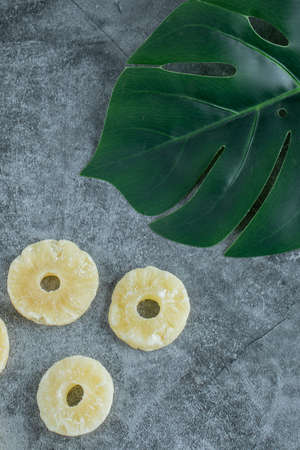 Dried pineapples with green leaves on a gray backgroundの写真素材