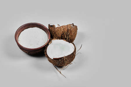 Half cut coconut and bowl of flour on the white backgroundの写真素材