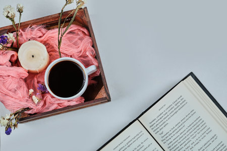 Book with blue candle and basket of cup of coffeeの写真素材