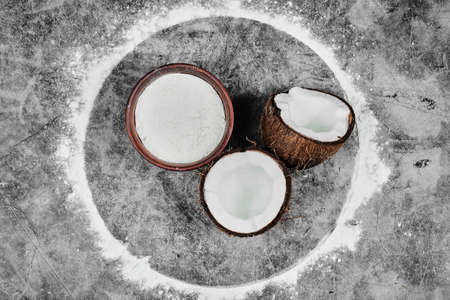 Half cut coconut and bowl of flour on the marble backgroundの写真素材
