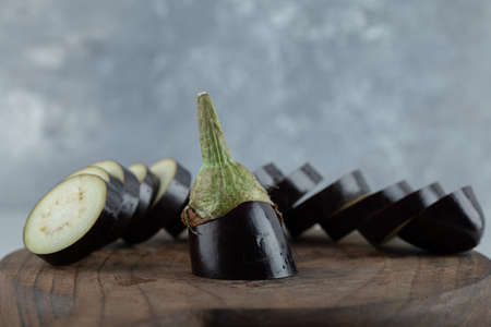 Sliced raw eggplant on wooden board. close up photo