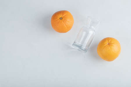 Fresh orange fruits with empty glass pitcherの写真素材