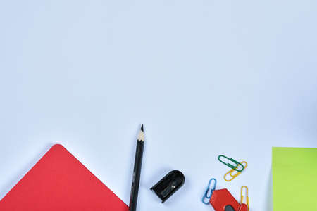 Office supplies, notebook, pencils and clips on blue background