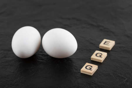 White chicken eggs on a black background