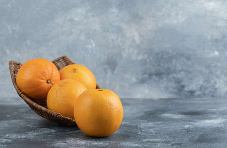 A wicker basket full of orange fruitsの写真素材