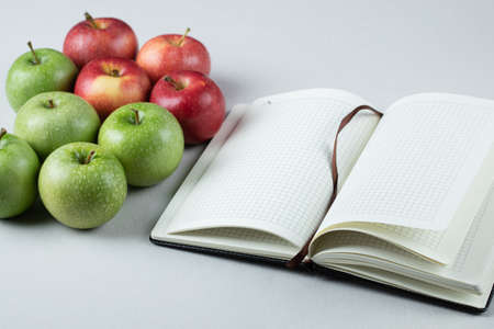 Green and red apples with a blank cookbook asideの写真素材