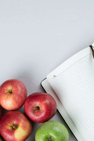 Red and green apples on a white background with a cookbook asideの写真素材