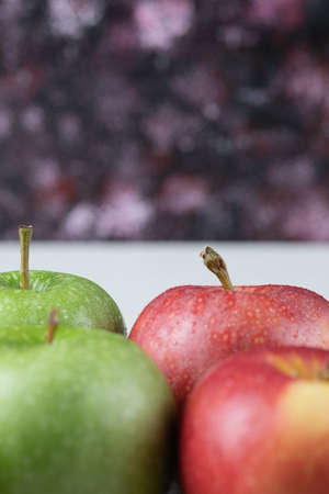 Green and red apples on dark background