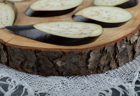 Close up photo of sliced organic eggplants on wooden boardの写真素材