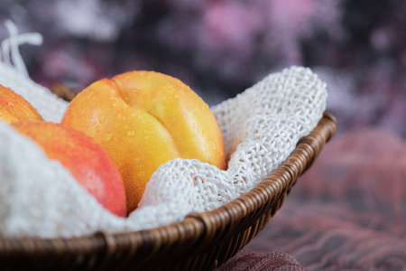 Apples in a wooden basket on a white burlapの写真素材
