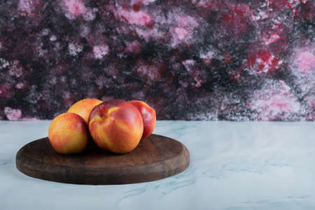 Yellow red peaches on a rustic wooden boardの写真素材