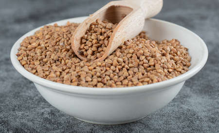 Bowl of raw buckwheat on marble backgroundの写真素材