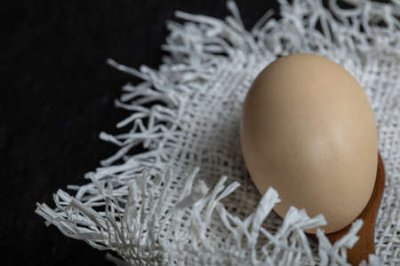 Wooden spoon of chicken egg on burlapの写真素材