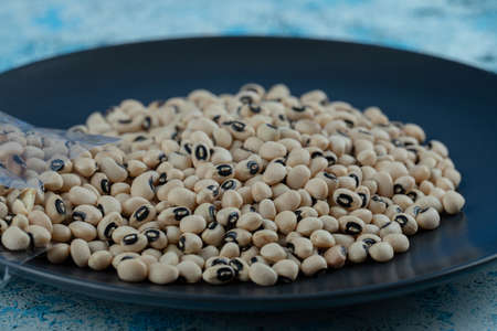 White raw beans on black plateの写真素材