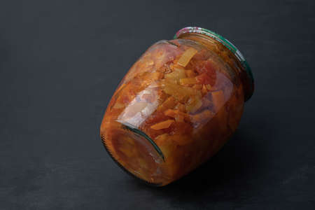 A glass jar with mixed vegetables on black backgroundの写真素材