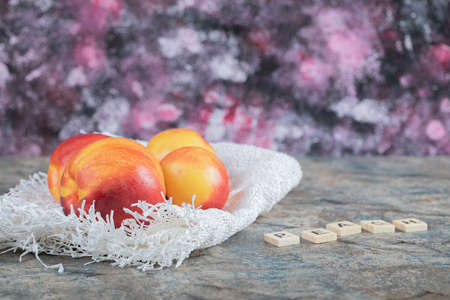 Yellow red peaches on a piece of white burlapの写真素材