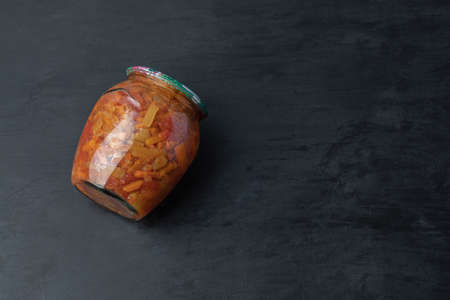 A glass jar with mixed vegetables on black background