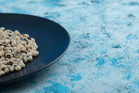 White raw beans on black plateの写真素材