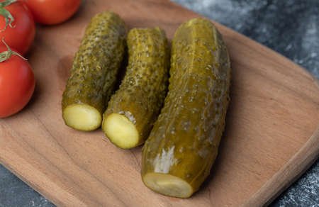 A wooden cutting board of tomatoes and pickled cucumberの写真素材