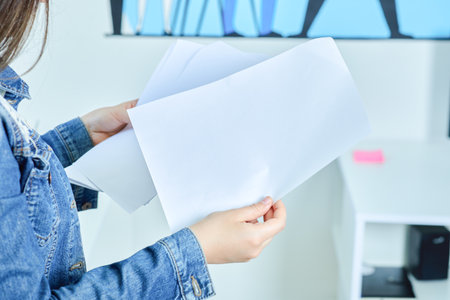 Young beautiful businesswoman reading papers in the office