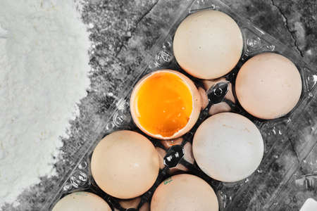 Flat lay closeup view raw and soft boiled eggs on plastic box