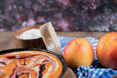 Strawberry syrup pie with yellow peaches aroundの写真素材