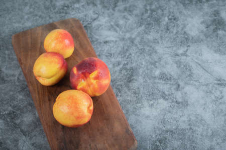 Yellow red peaches on a wooden platterの写真素材