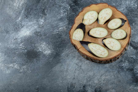 Pile of sliced aubergine on wooden board. Top viewの写真素材