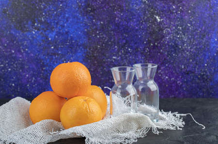 Fresh orange fruits with glass cups isolated on a black backgroundの写真素材