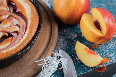 Strawberry syrup pie with yellow peaches aroundの写真素材