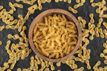 A wooden bowl full of raw girandole pasta