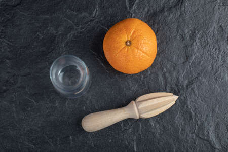 Fresh orange fruit with a glass cup isolated on a black backgroundの写真素材
