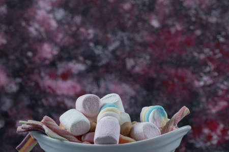Jellybeans and marshmallows in a white ceramic plateの写真素材