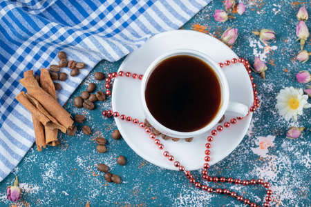 A cup of tea with cinnamon sticks on the tableの写真素材