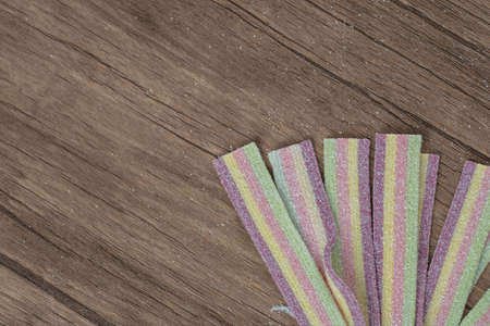 Long narrow rainbow jellybeans on a wooden board