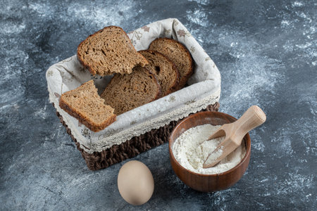 Slices of brown bread on a basket on a gray backgroundの写真素材