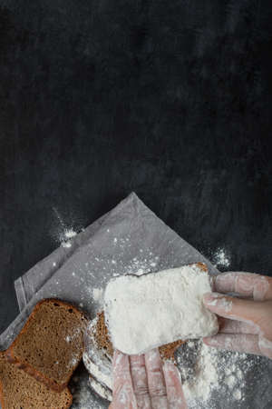 Woman hand holding a slice of bread with flourの写真素材