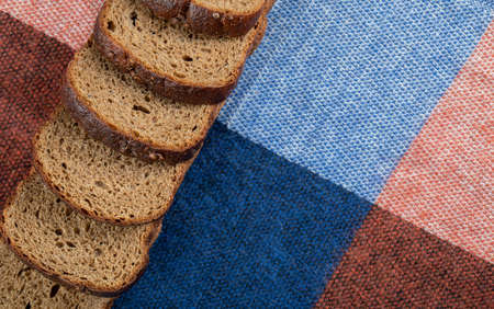 A line of slices of brown bread on a tableclothの写真素材
