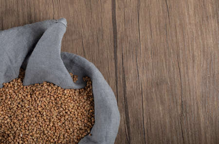 Pile of uncooked buckwheat in gray clothの写真素材