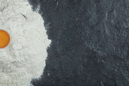 Flour with raw yolk on a gray background