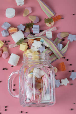 Mixed shape marshmallows out of drink cups on pink backgroundの写真素材
