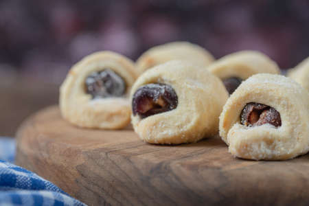 Cookie rolls with strawberry confiture on a wooden boardの写真素材