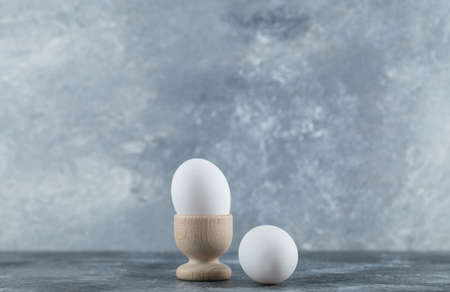 Egg cup and eggs on grey backgroundの写真素材