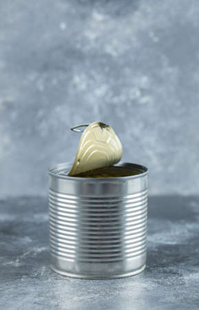 Vertical photo of opened tin green olives on grey backgroundの写真素材